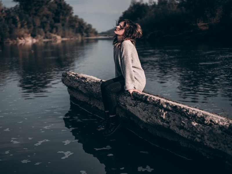 Vrouw reflecteert bij het water over de emotionele band met haar moeder en familiepatronen